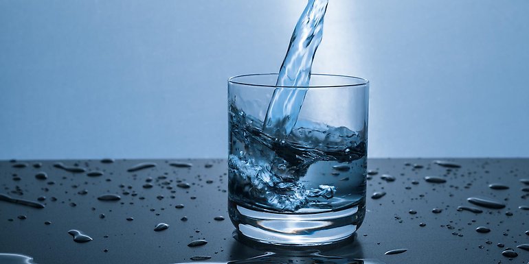 Bild på vatten som hälls i ett dricksglas